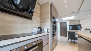 Een moderne keuken met roestvrijstalen apparatuur, een inbouwoven en een groot raam boven de aanrecht.