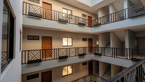 Ein mehrgeschossiges Interieur mit Balkonen, Treppen und Türen.