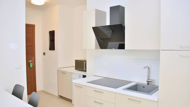 A compact kitchen with a microwave, sink, and cabinets. - Relax Vibes Near the Beach (San Michele al Tagliamento)