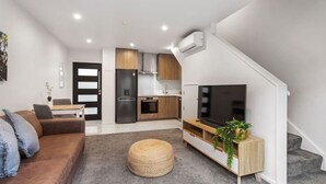 Un appartement moderne comprenant un salon, une cuisine et un coin repas.