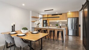 Una cocina moderna con una isla central, armarios de madera y electrodomésticos de acero inoxidable.