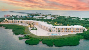A resort with multiple buildings, a swimming pool, and a bridge connecting to the mainland. - Marathon Oceanfront Suite | King Bed + Balcony (Marathon)