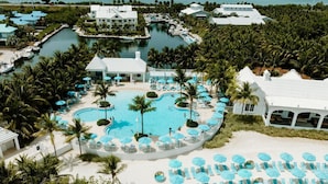 A resort with multiple swimming pools, a beach area with sun loungers, and a marina. - Marathon Oceanfront Suite | King Bed + Balcony (Marathon)