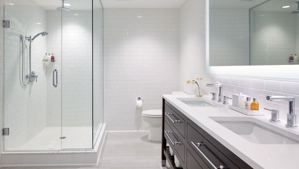A modern bathroom with a glass-enclosed shower, a white toilet, and a vanity with a mirror. - Marathon Oceanfront Room | King Bed + 5 Pools (Marathon)