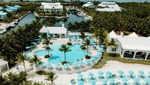 A resort with multiple swimming pools, a beach area with sun loungers, and a marina. - Marathon Beachfront | ADA 2 Queens + Veranda (Marathon)