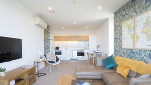 A modern apartment with a living room, kitchen, and dining area.