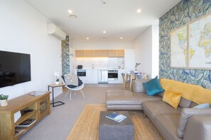 Un appartamento moderno con soggiorno, cucina e zona pranzo.
