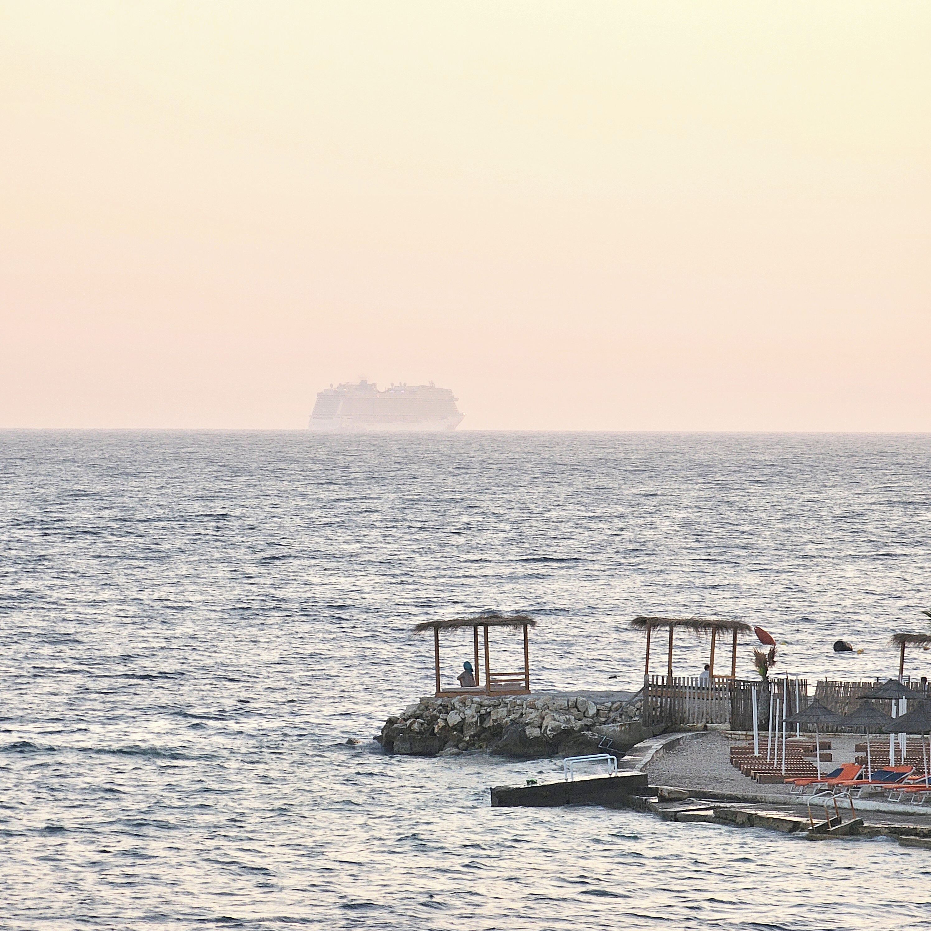 A pier with a small structure and a lifebuoy.