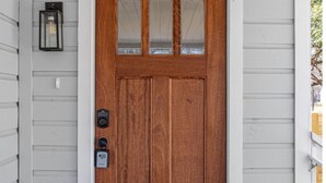 A wooden front door with a glass panel, a doorbell, and a mailbox. - Stylish Spacious Comfort 4BR 3BA Downtown Gem (San Antonio)
