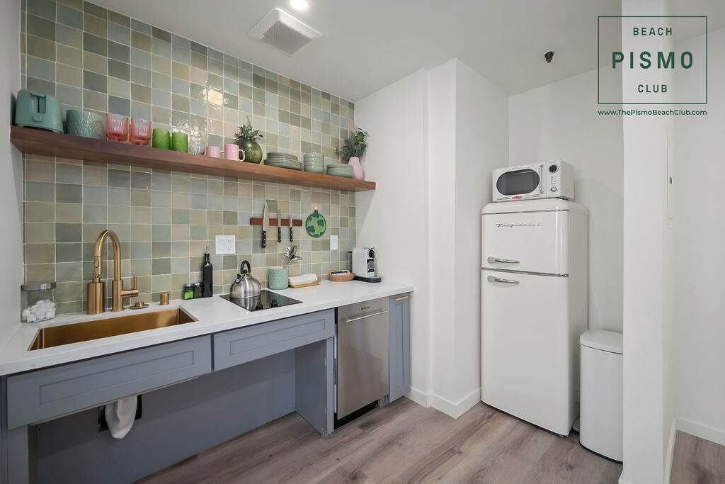 Une cuisine moderne avec un réfrigérateur blanc, un évier et un égouttoir à vaisselle.