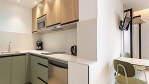 A modern kitchen with a dishwasher, microwave, and coffee maker. - Sholeo Lodges Las Canteras Flats (Las Palmas de Gran Canaria)