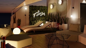 A modern outdoor lounge area with a neon sign, lounge chairs, and potted plants. - Sholeo Lodges Las Canteras Flats (Las Palmas de Gran Canaria)