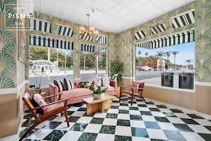 A lounge area with a checkered floor, striped awnings, and a view of the street.