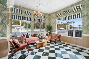 A lounge area with a checkered floor, striped awnings, and a view of the street. - Downtown View Suite at Pismo Beach Club (Pismo Beach)