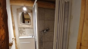 Une petite salle de bain avec une douche, des toilettes et un lavabo.