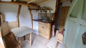 Une cuisine rustique avec des poutres en bois, une table à carreaux et un évier.