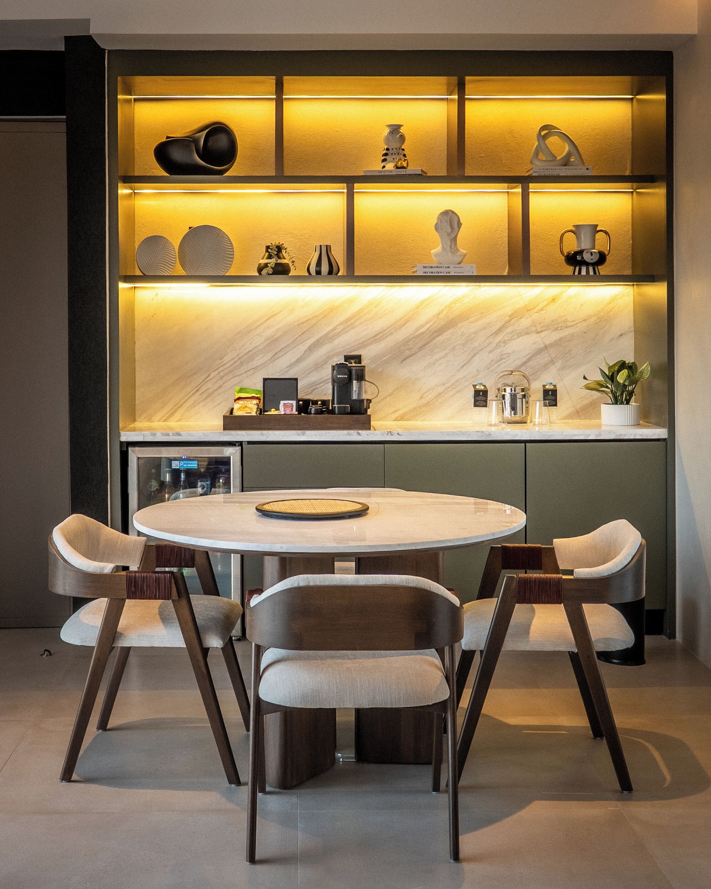 A modern kitchen with a marble backsplash, a round dining table, and four chairs.