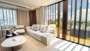 A modern living room with a sofa, coffee table, and a view of the city through large windows.