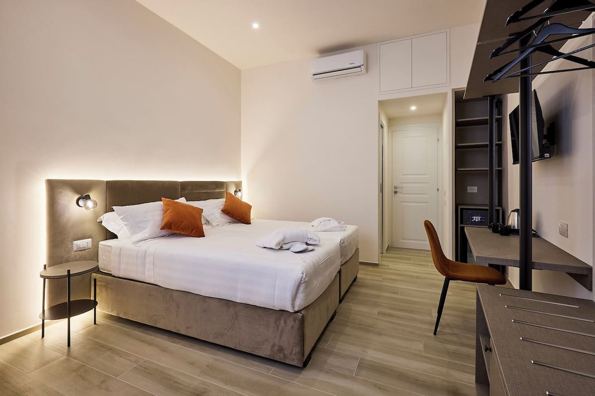 Una habitación de hotel moderna con una cama grande, un escritorio y una silla.