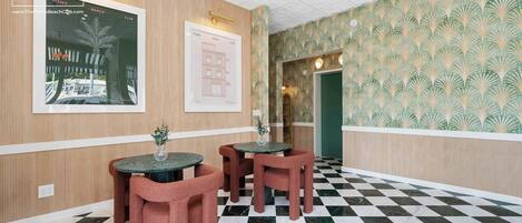 A checkered floor, wooden panel walls, and a framed picture of a building.