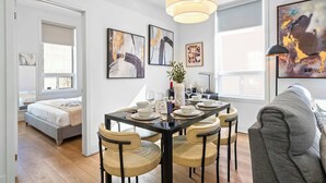 Een modern interieur met een eethoek, een bed en kunstwerken aan de wanden.