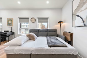 Une chambre à coucher moderne avec un lit, un bureau et une fenêtre.