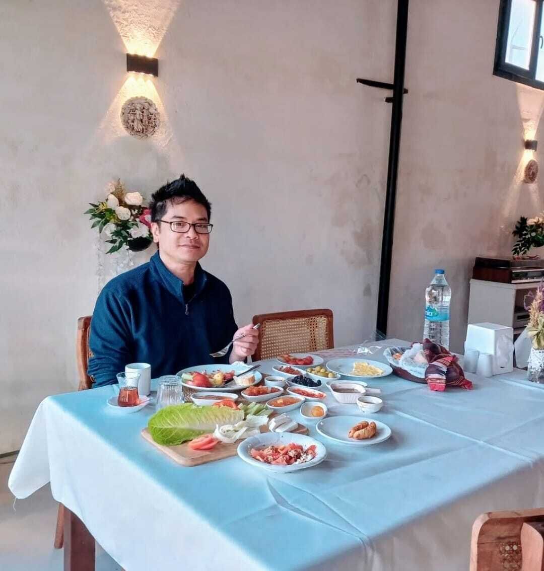 A dining table set with various dishes, a water bottle, and a vase of flowers.