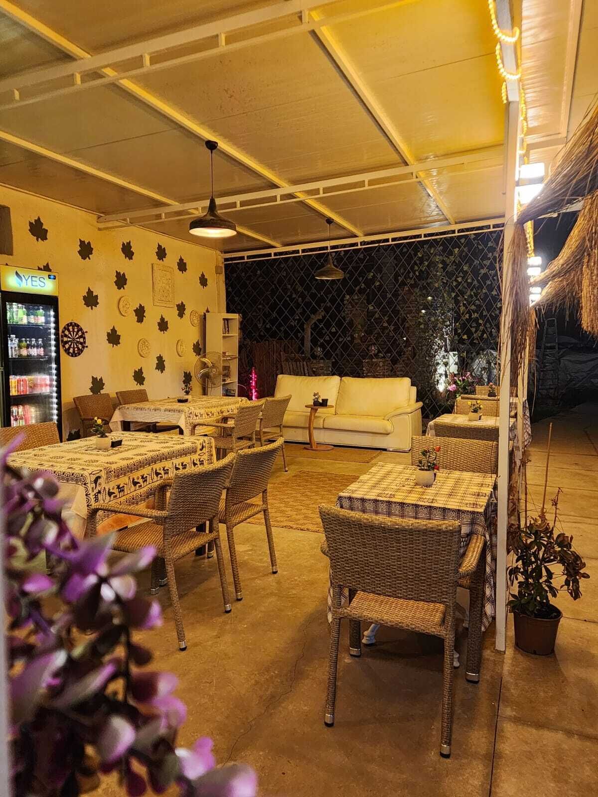 Un rincón interior acogedor con mobiliario de mimbre, un sofá blanco y una mesa de comedor.