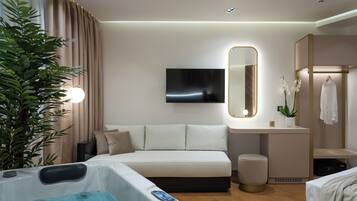 Een moderne hotelkamer met een bed, een grote spiegel, een televisie, een jacuzzi en een plant.