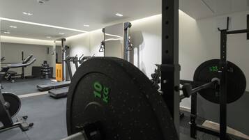 A gym with weightlifting equipment, treadmills, and exercise machines.