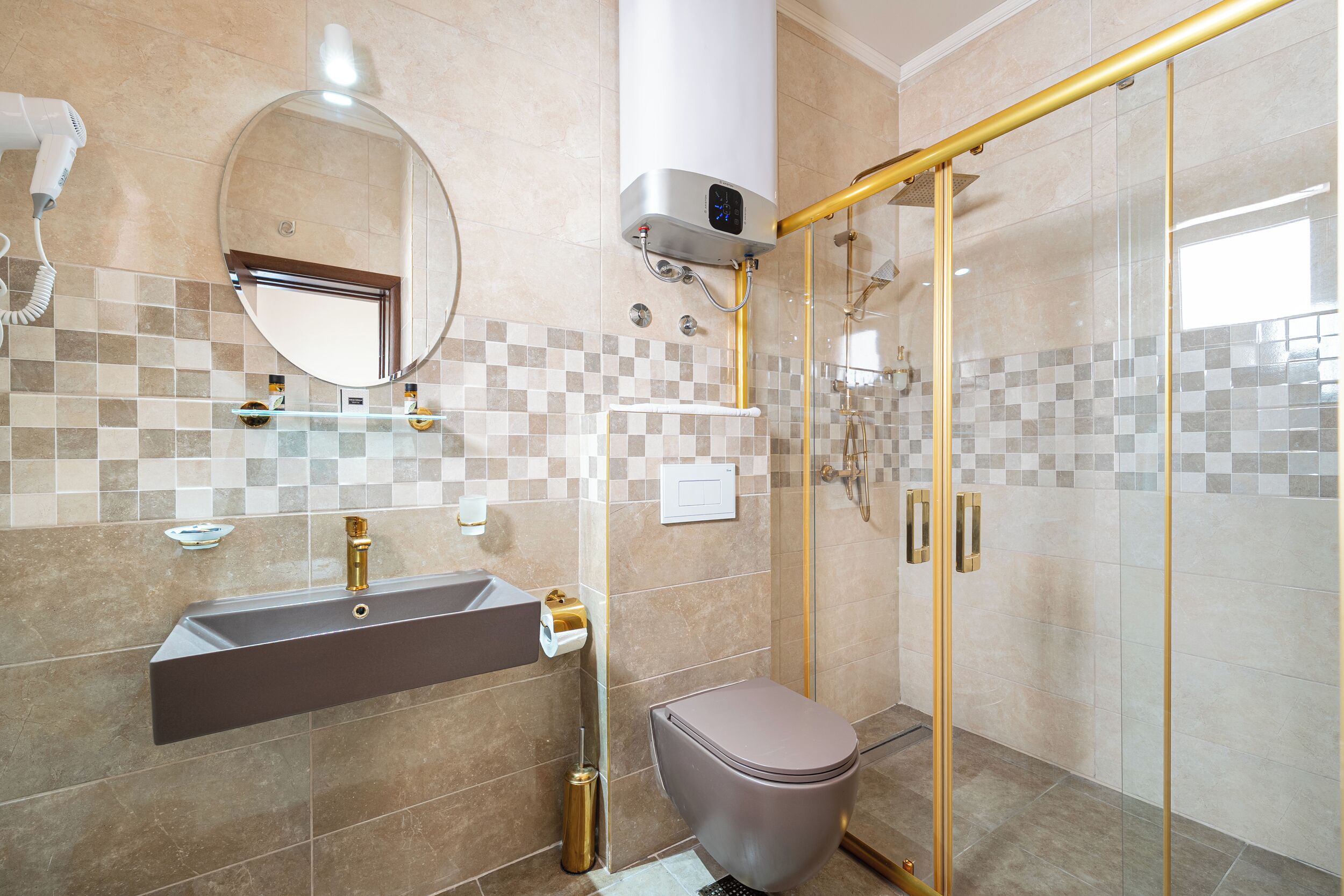 Een moderne badkamer met een wastafel, spiegel, toilet en douchecabine.