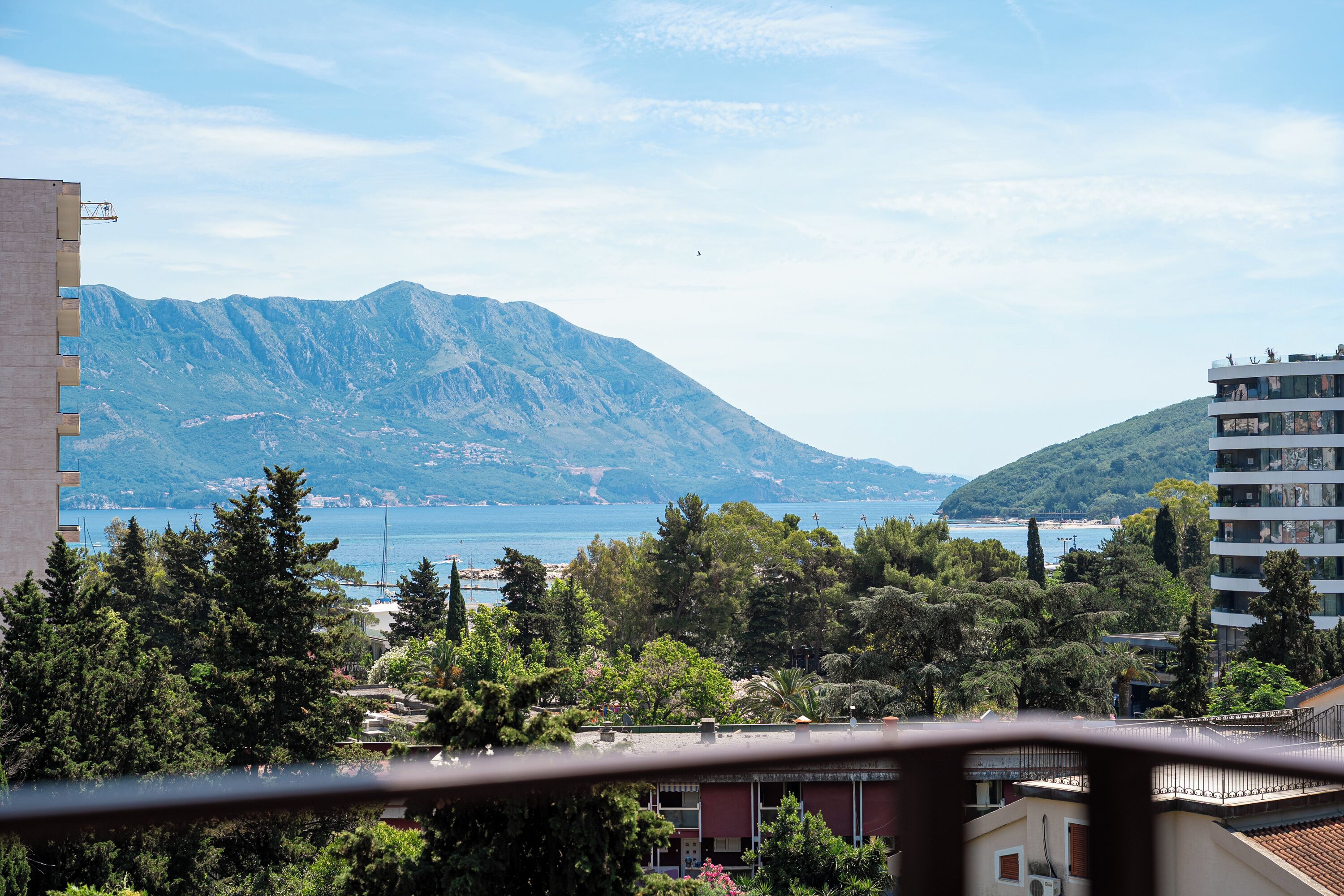 A mountainous landscape with a body of water, buildings, and trees.