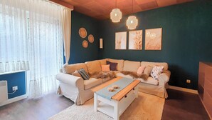 A cozy living room with a beige sofa, a wooden coffee table, and a white rug. - Friendly Home - Villa Verde - near Phantasialand/Cologne/Bonn (Bornheim)