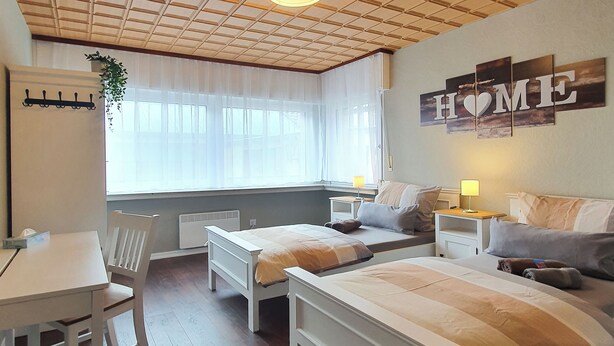 A bedroom with a wooden ceiling, a bed, a desk, and a chair. - Friendly Home - Villa Verde - near Phantasialand/Cologne/Bonn (Bornheim)