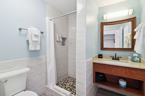 Un baño con ducha, inodoro y lavamanos.