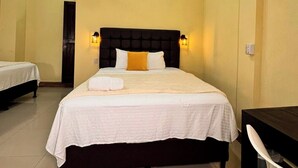 A hotel room with a large bed, two bedside tables, a ceiling fan, and a small window. - Hotel Maya Magic Petén (Flores)