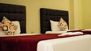 A hotel room with two beds, each with a black headboard and white bedding. - Hotel Maya Magic Petén (Flores)