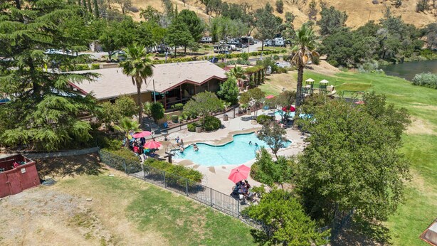 An aerial view of a resort with a swimming pool, outdoor seating, and a golf course in the background. - Cottage, Sleeps 4 - Scenic Cottage, 1 Bedroom, Sleeps 4 (Winters)