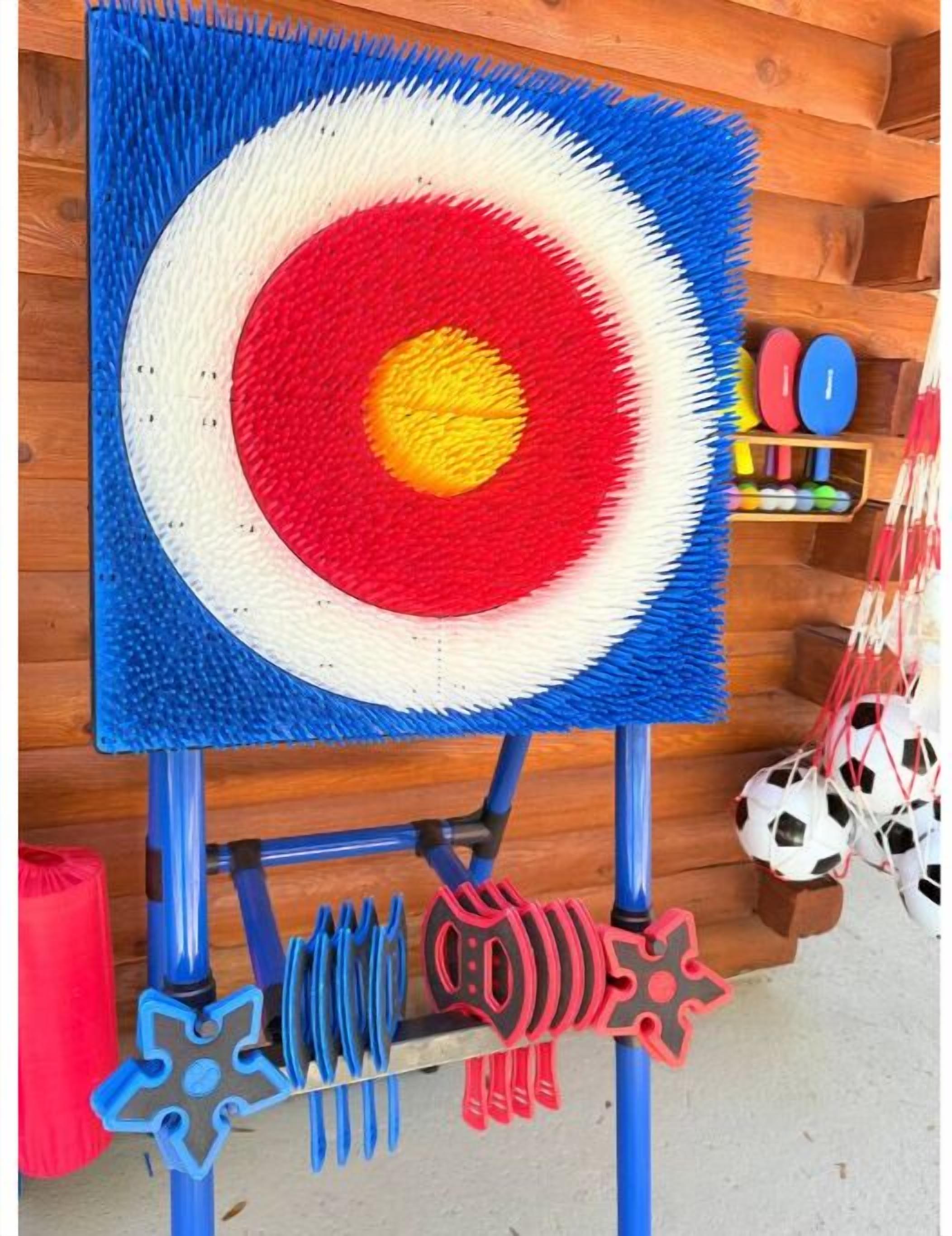 A target board with a colorful bullseye design, mounted on a stand with various sports equipment below.
