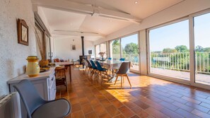Enjoy a spacious room with a high ceiling, large windows, and a dining area, kitchen, and seating area.