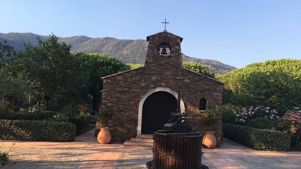 A small brick church with a bell tower, surrounded by well-maintained gardens and a stone pathway. - T2 en rez de jardin , proche plage de St Clair et commerces (LE LAVANDOU)