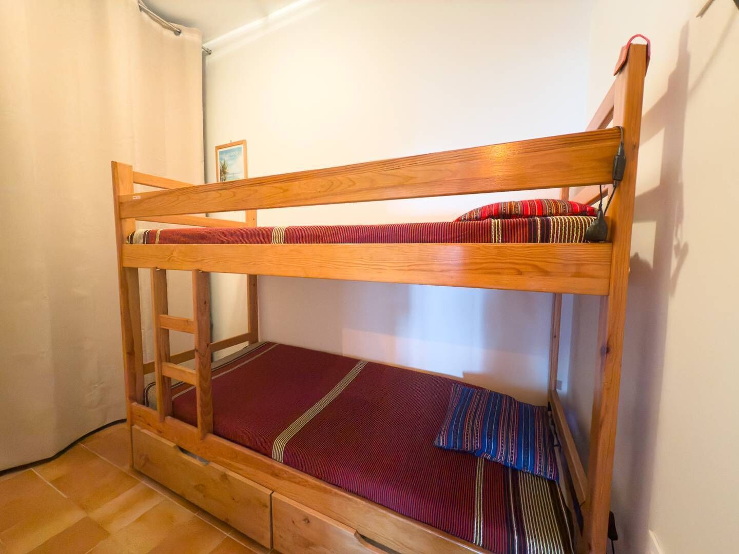 Ein Etagenbett mit Holzbettgestell und zwei Schlafebenen.