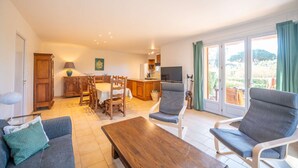 A spacious living area with a sofa, a wooden coffee table, and a dining set. - Maison, climatisée plage St Clair et commerces (LE LAVANDOU)