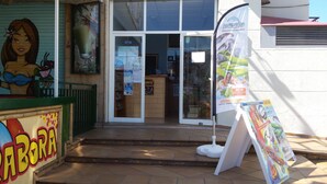 Ein Schaufenster mit einem Schild, auf dem "ABORRA" steht, und einem großen Plakat, das ein Delfinarium bewirbt.