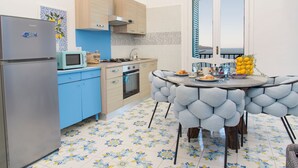 Une cuisine moderne équipée d’un réfrigérateur, d’un four à micro-ondes, d’une cuisinière et de meubles de rangement bleus.