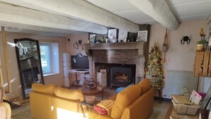 Una sala de estar acogedora con chimenea, sofá amarillo y un árbol de Navidad.