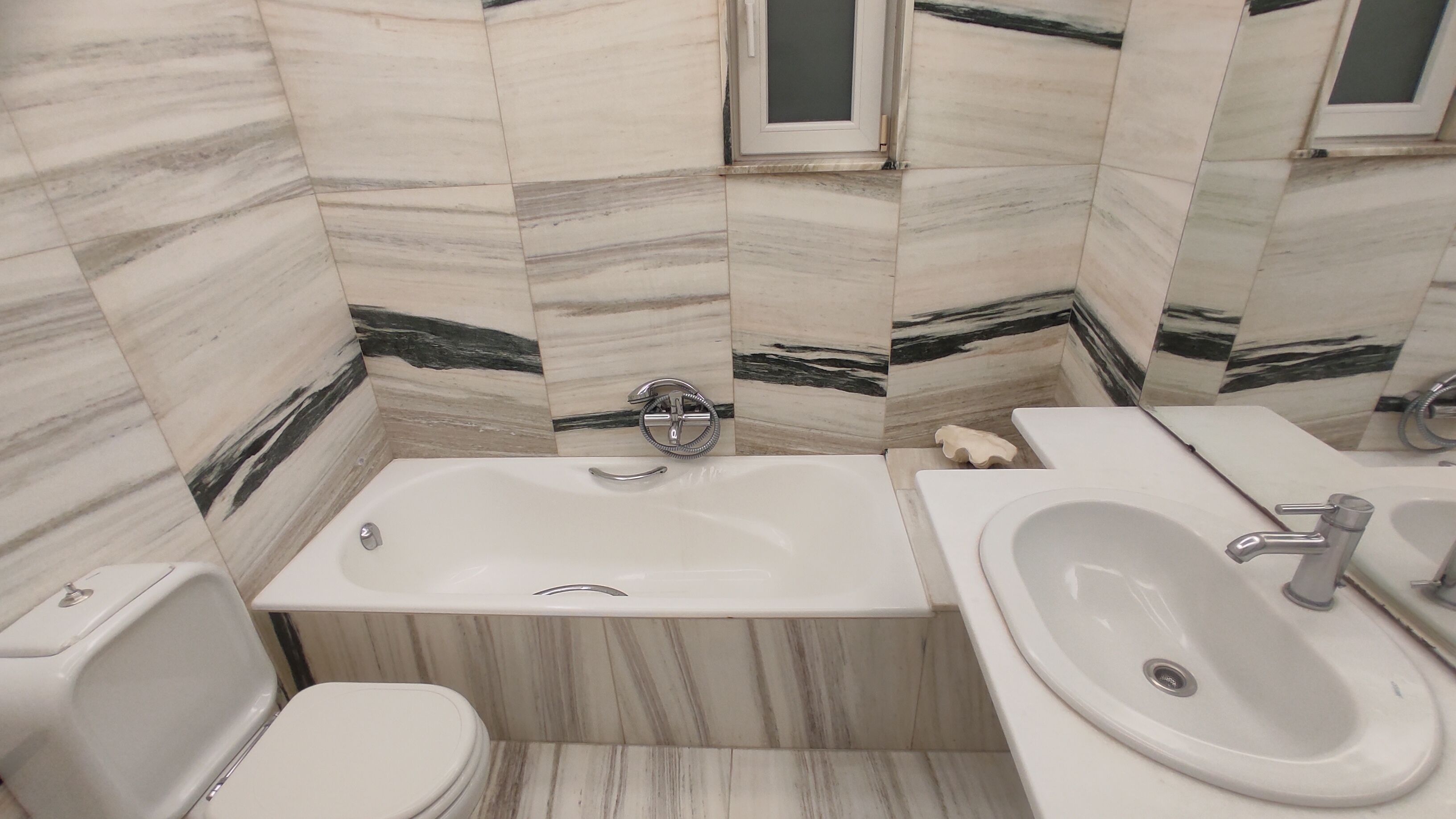 Ein Badezimmer mit Badewanne, Toilette und Waschbecken.