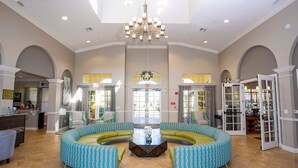 A spacious lobby with a central seating area, a chandelier, and a reception desk. - Comfortable 3BR Near Convention Center Epic Park (Orlando)