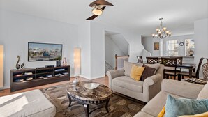 A modern living room with a sofa, coffee table, and entertainment unit. - Comfortable 3BR Near Convention Center Epic Park (Orlando)
