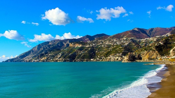 A coastal town with a beach, mountains, and clear blue sky. - L'Incanto House (Salerno)